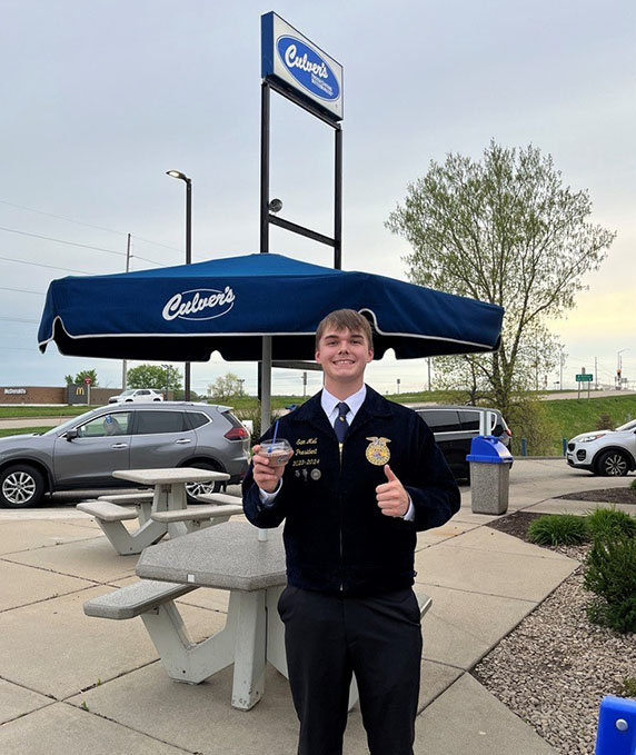 FFA members holds scoop of Custard in front of Culver’s picnic table.